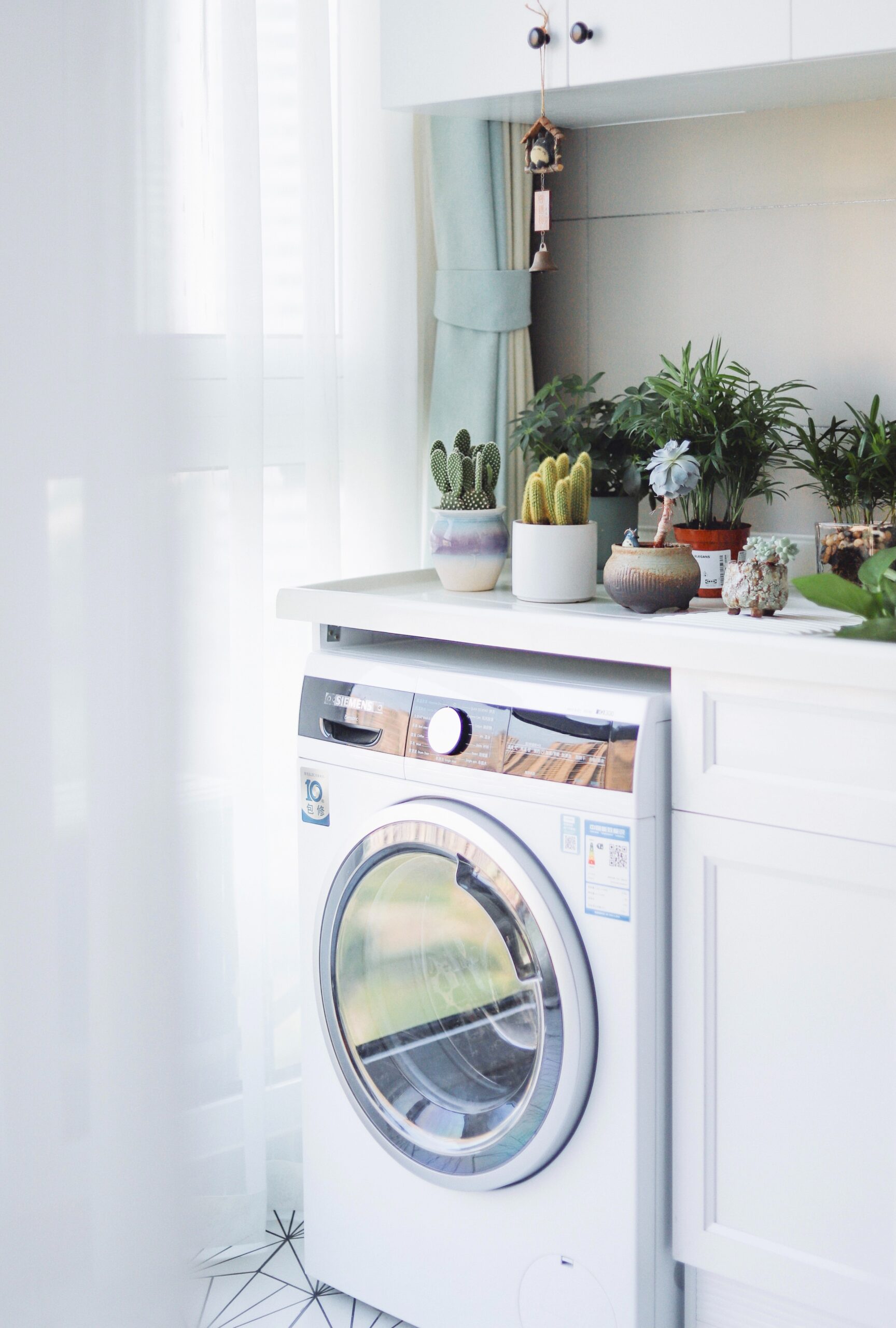 white front load Electric Dryer beside white wooden cabinet